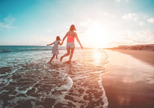 A mother and child running on the beach and enjoying their vacation, thanks to having Short-Term Rentals in St. Petersburg FL